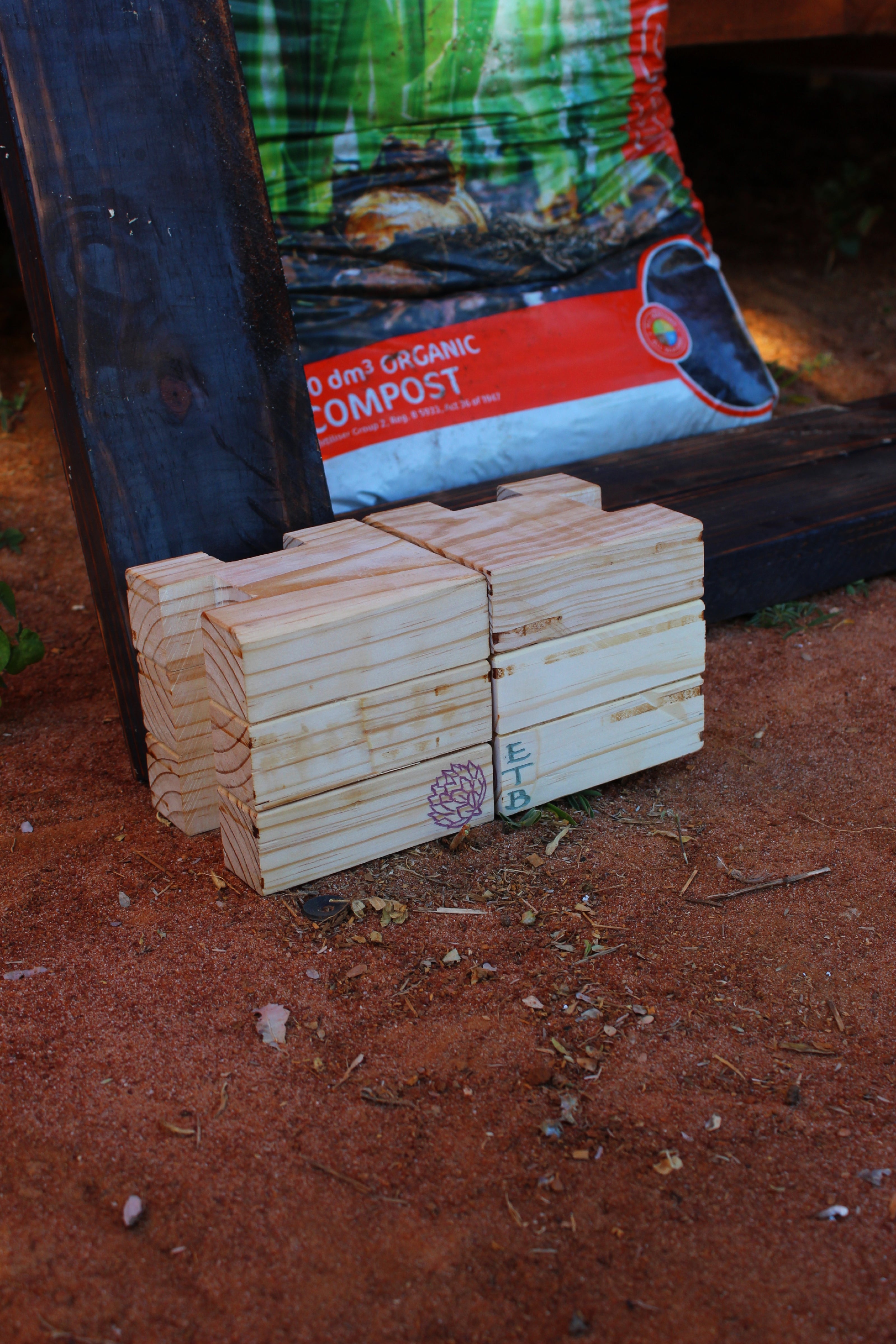Stack of Botanical Blocks on a red dirt surface with a compost bag in the background.
